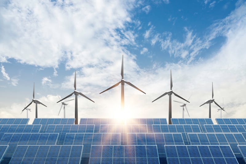 Solar cell plant and wind generators under blue sky on sunset