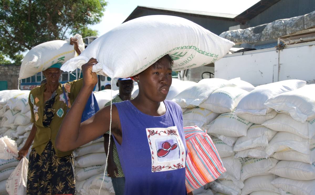 Women who received bags of lentils from a distribution site in Gonaives, Haiti, carry their food and cooking oil off to their homes weeks after Hurricane Ike. Photo: ID​ 7543780 ©​ David Snyder​ |​ Dreamstime.com