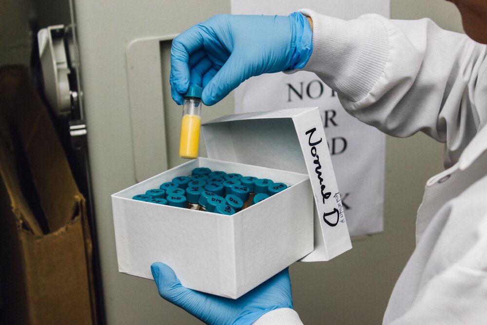 A scientist holding a vial of blood plasma.