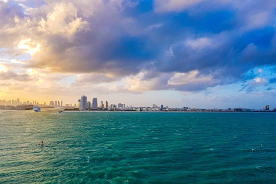 a shot of the ocean with miami skyline in the far background