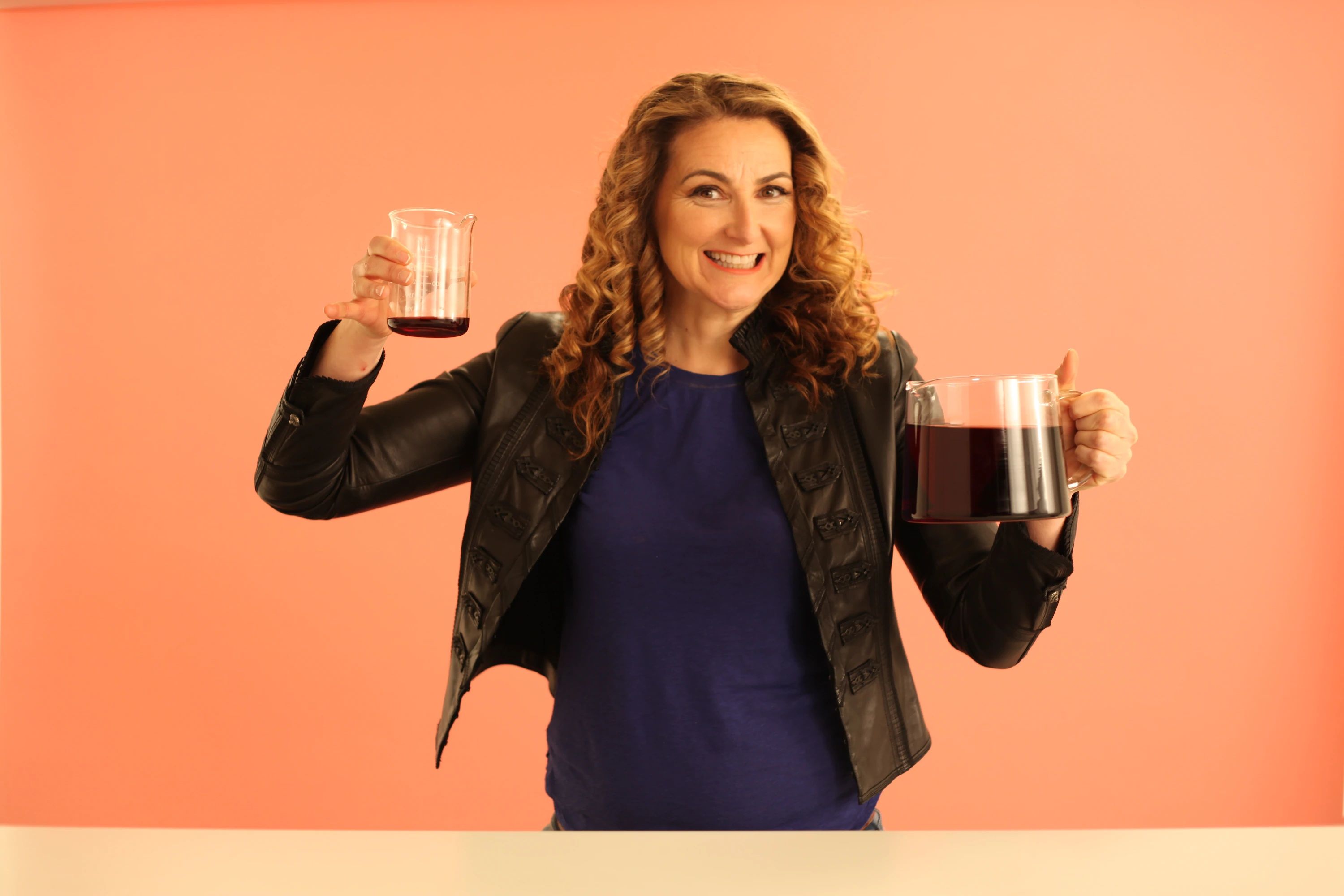 Dr. Jen Gunter holding beakers filled with fake blood representing possible options for flow volume.