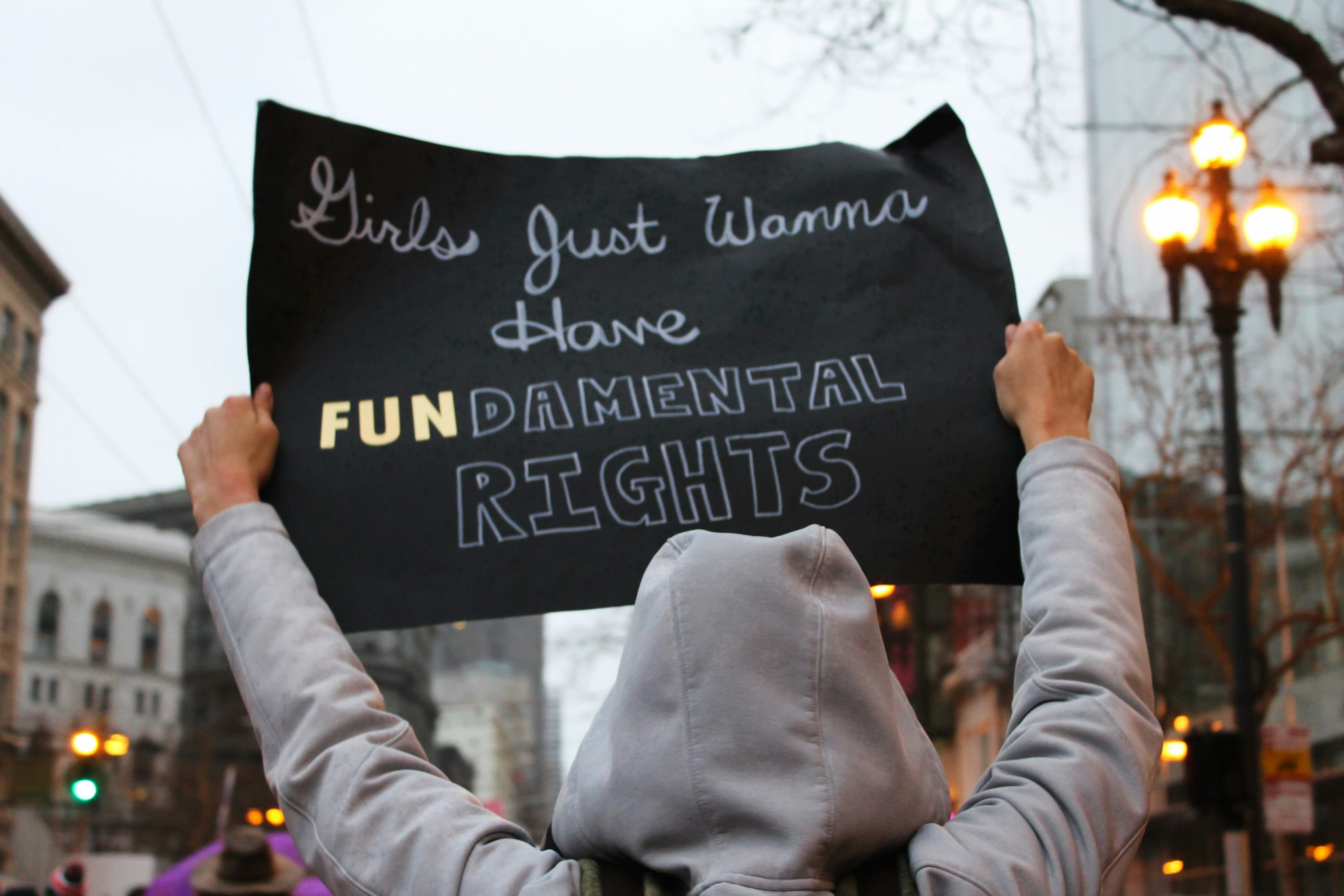 woman holding a sign that says girls just wanna have fundamental rights