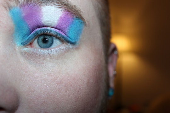 close up of a person with eye makeup in the colors of a trans flag