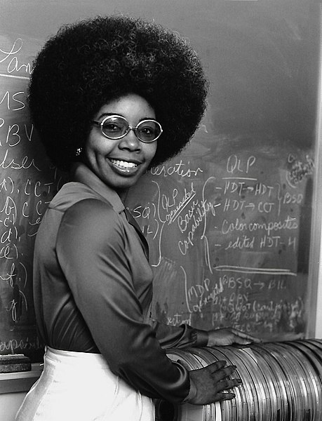  Dr. Valerie Thomas in 1979 standing with a stack of early Landsat Computer Compatible Tapes (CCTs). Thomas was responsible for the development of early Landsat digital media formatting