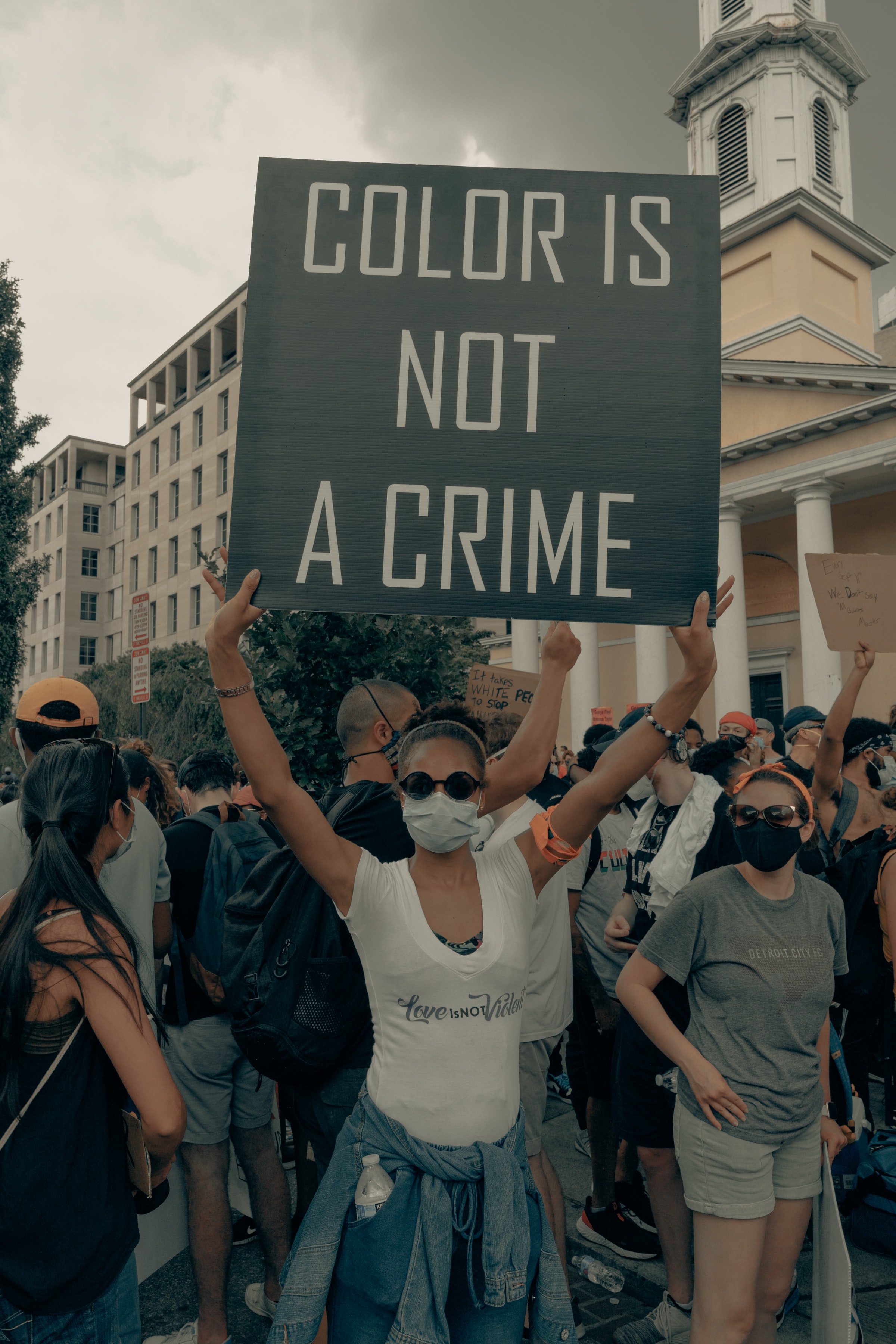 A person holds up sign ("Color is not a crime") at the Black Lives Matter protest in Washington DC 
