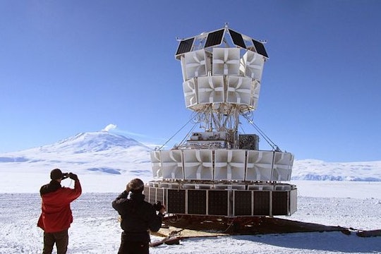 ANITA experiment two people looking at a giant white ballon structure in antarctica