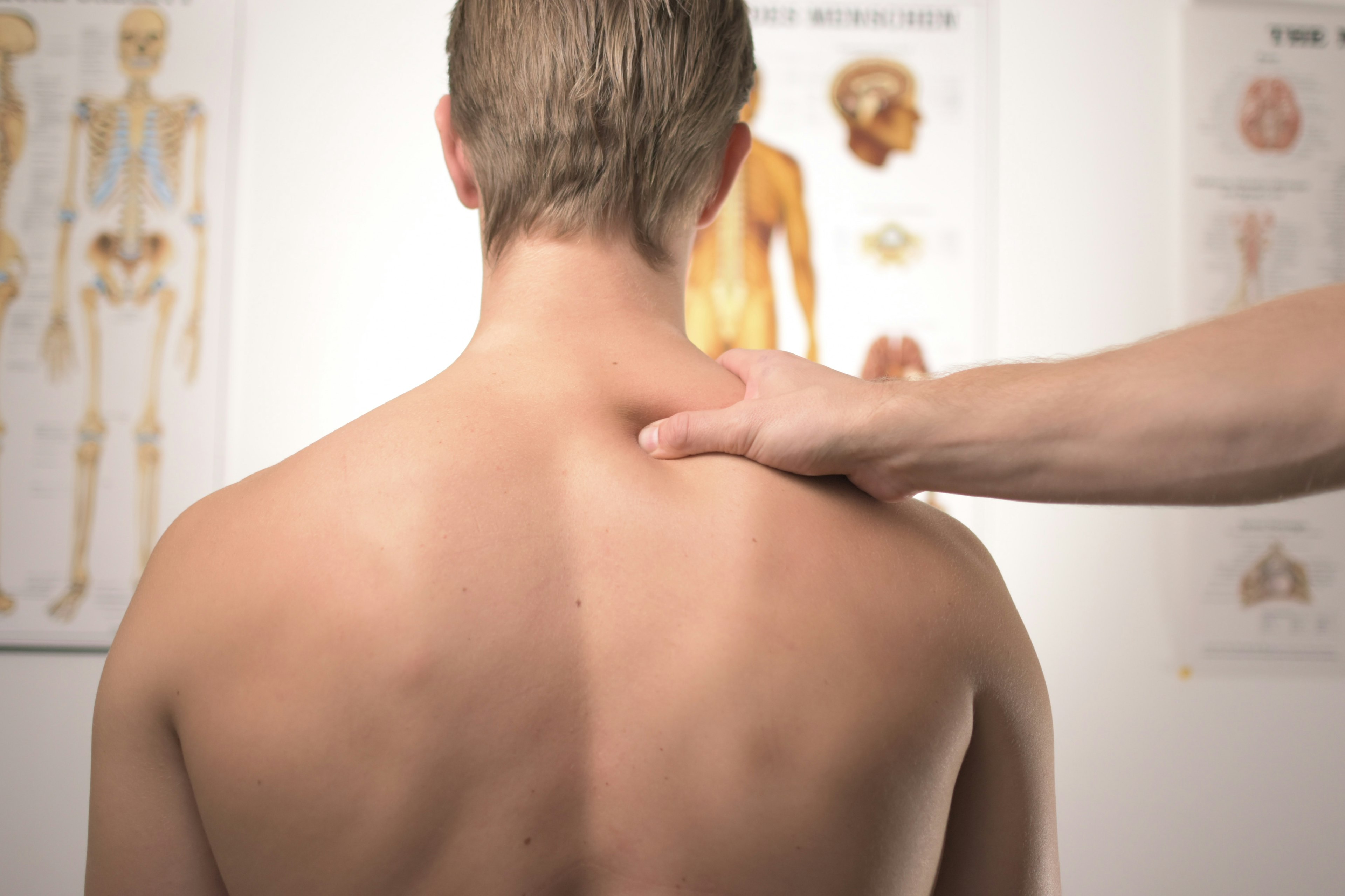 A man in a doctor's office with neck and shoulder pain