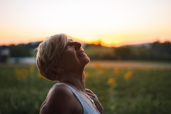 a woman looking up at the sky smiling slightly