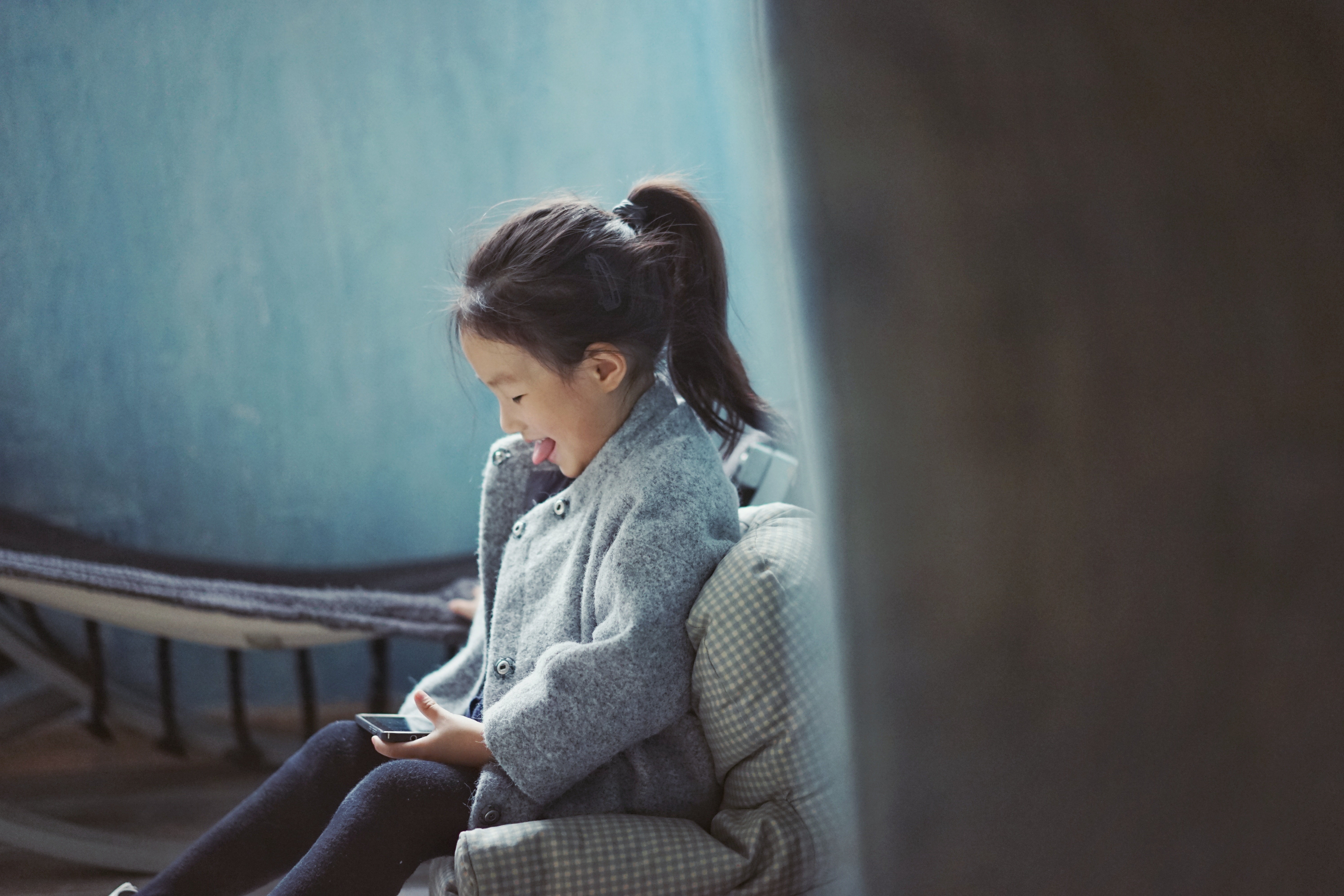 girl laughing while playing on phone