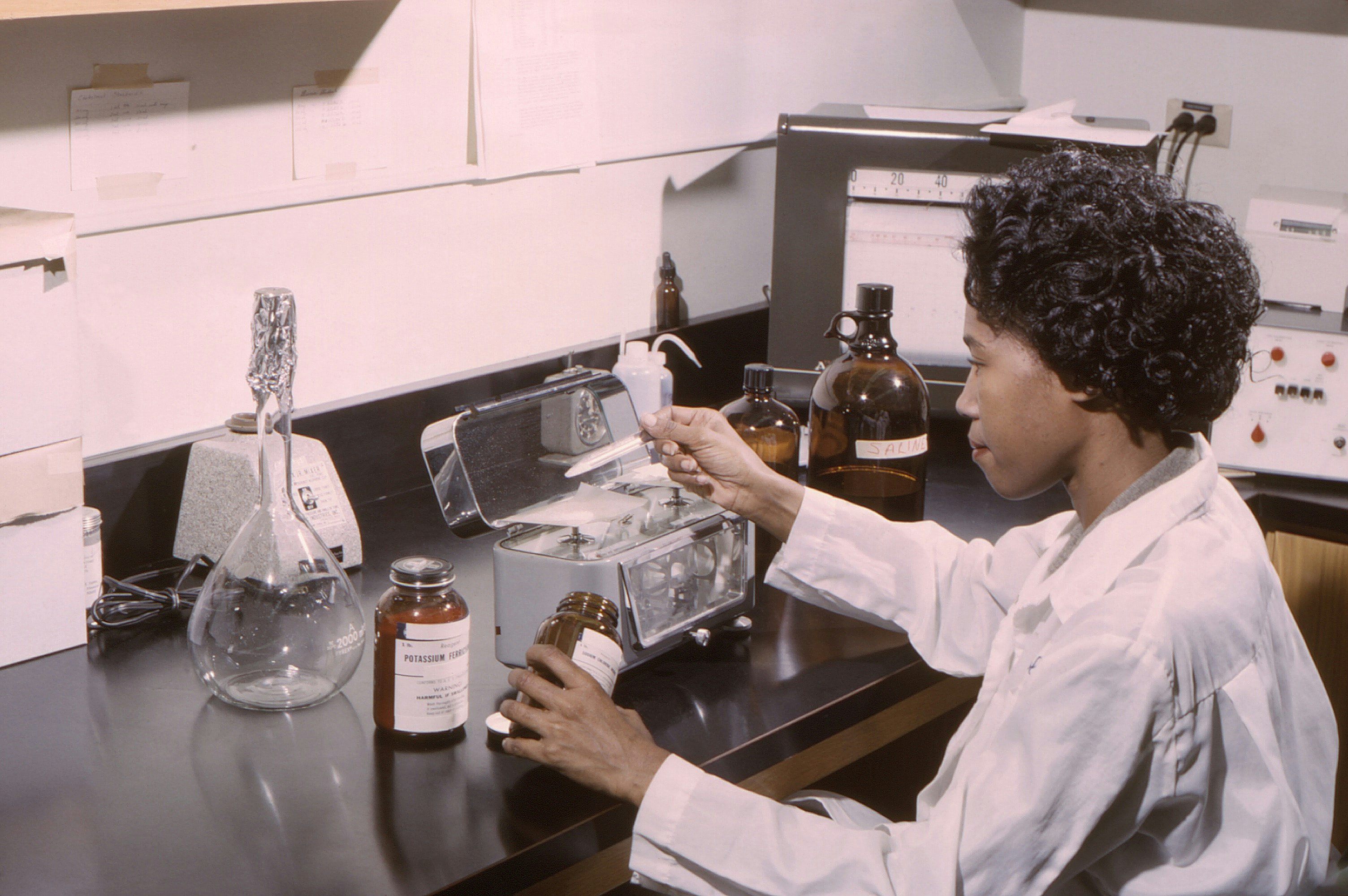 A scientist using a scale to weigh out reagents for sample analysis.
