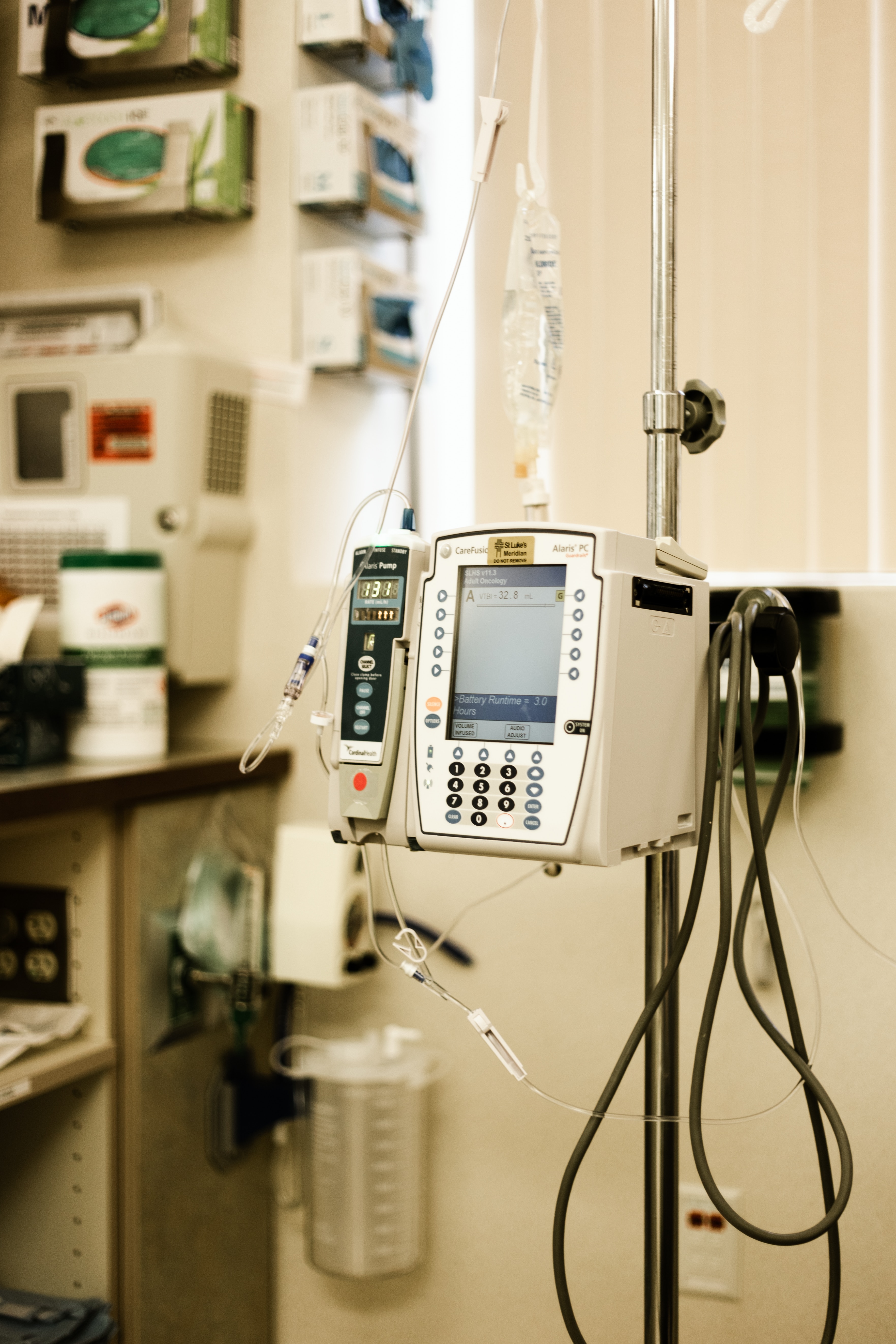A picture of an IV drip and a heart rate monitor in a hospital room.