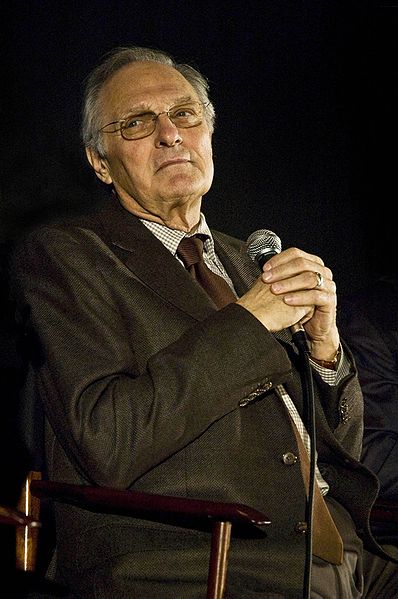 actor alan alda holding a microphone