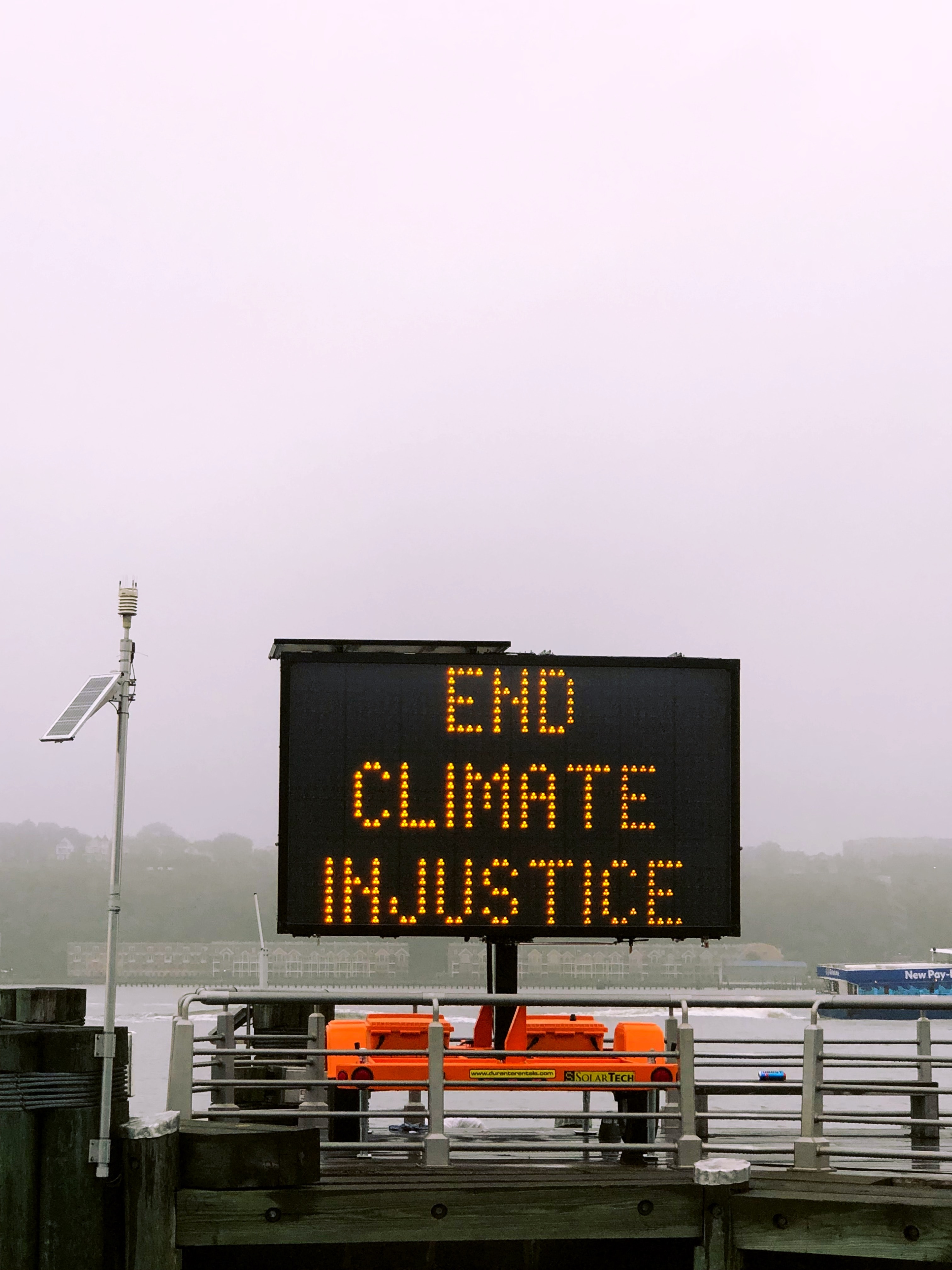 sign that says "end climate injustice"