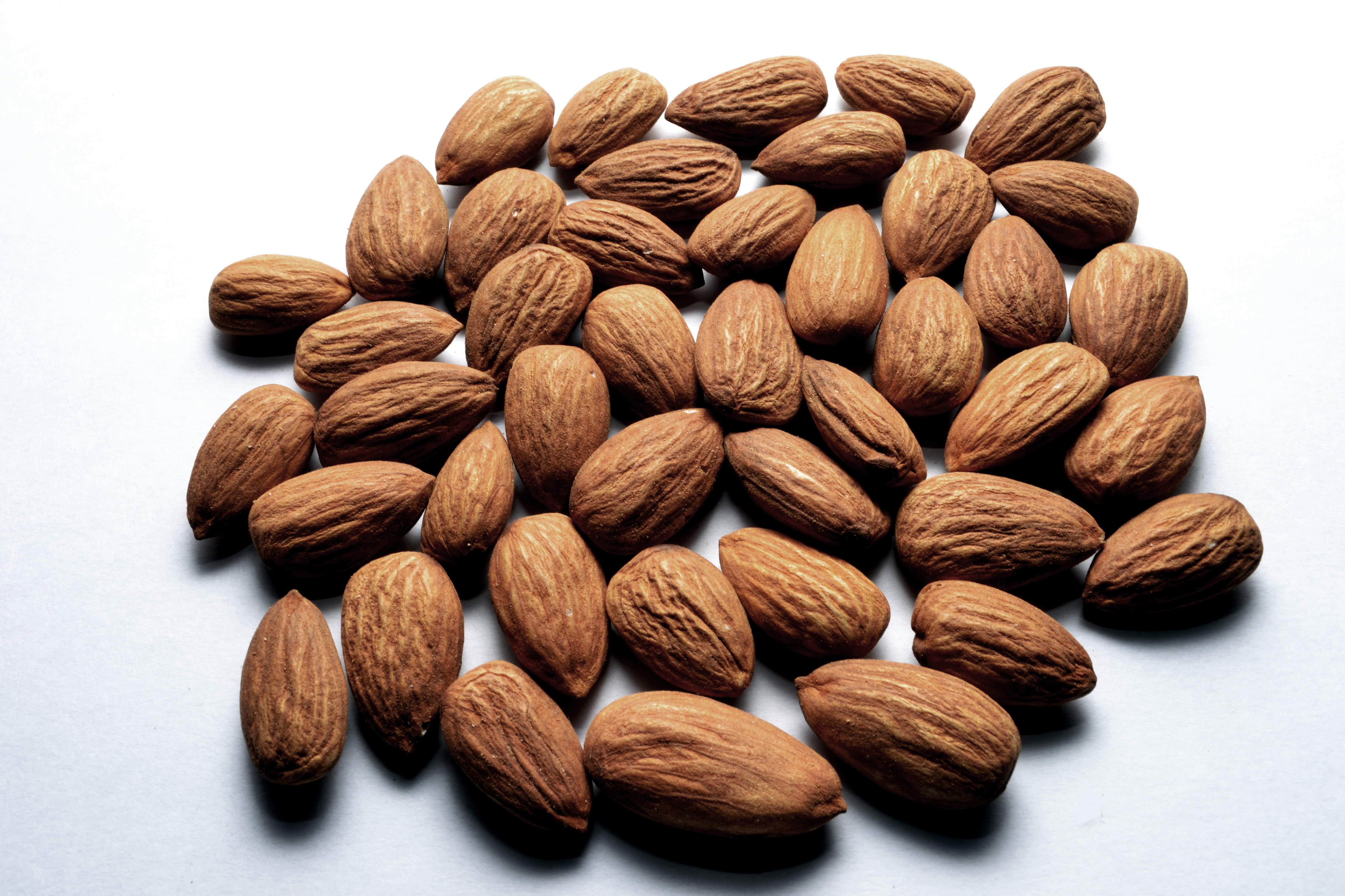 A bunch of almonds on a white background.