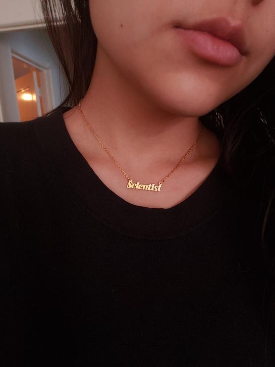 woman wearing a necklace that says scientist
