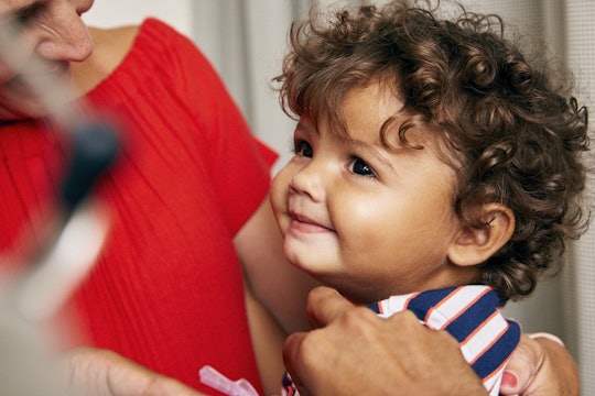 A toddler smiling and receiving a vaccine