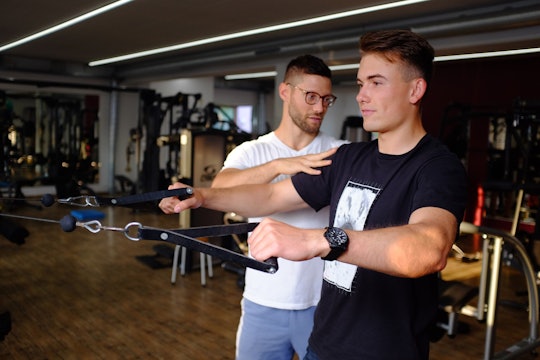 A man going through physiotherapy/physical therapy in a gym.