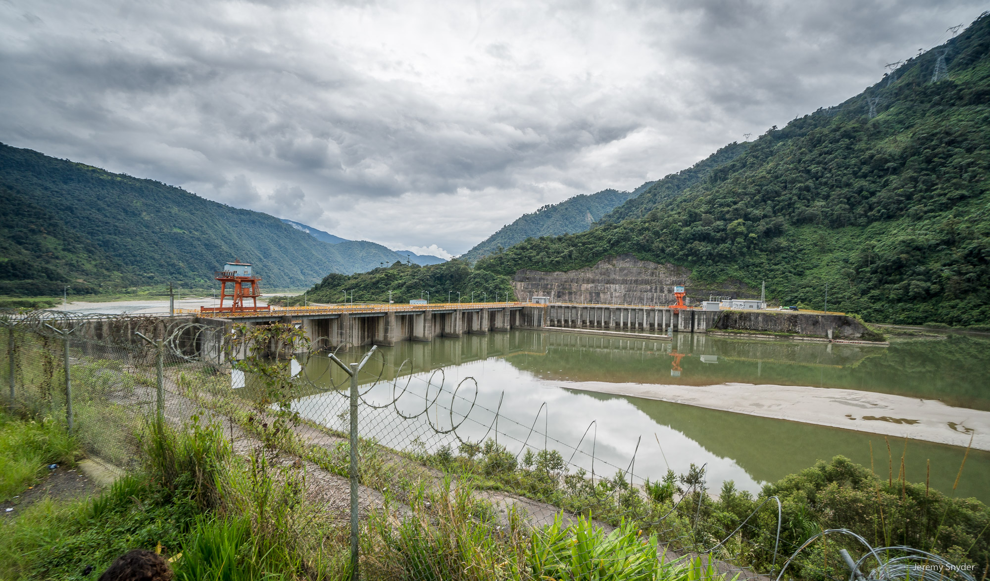 A dam and reservoir with muddy water