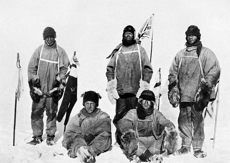 five men in a black and white photograph taken in Antarctica