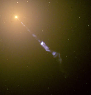 The elliptical galaxy M87 with its strikingly huge jet coming from the central black hole as imaged by the Hubble Space Telescope.