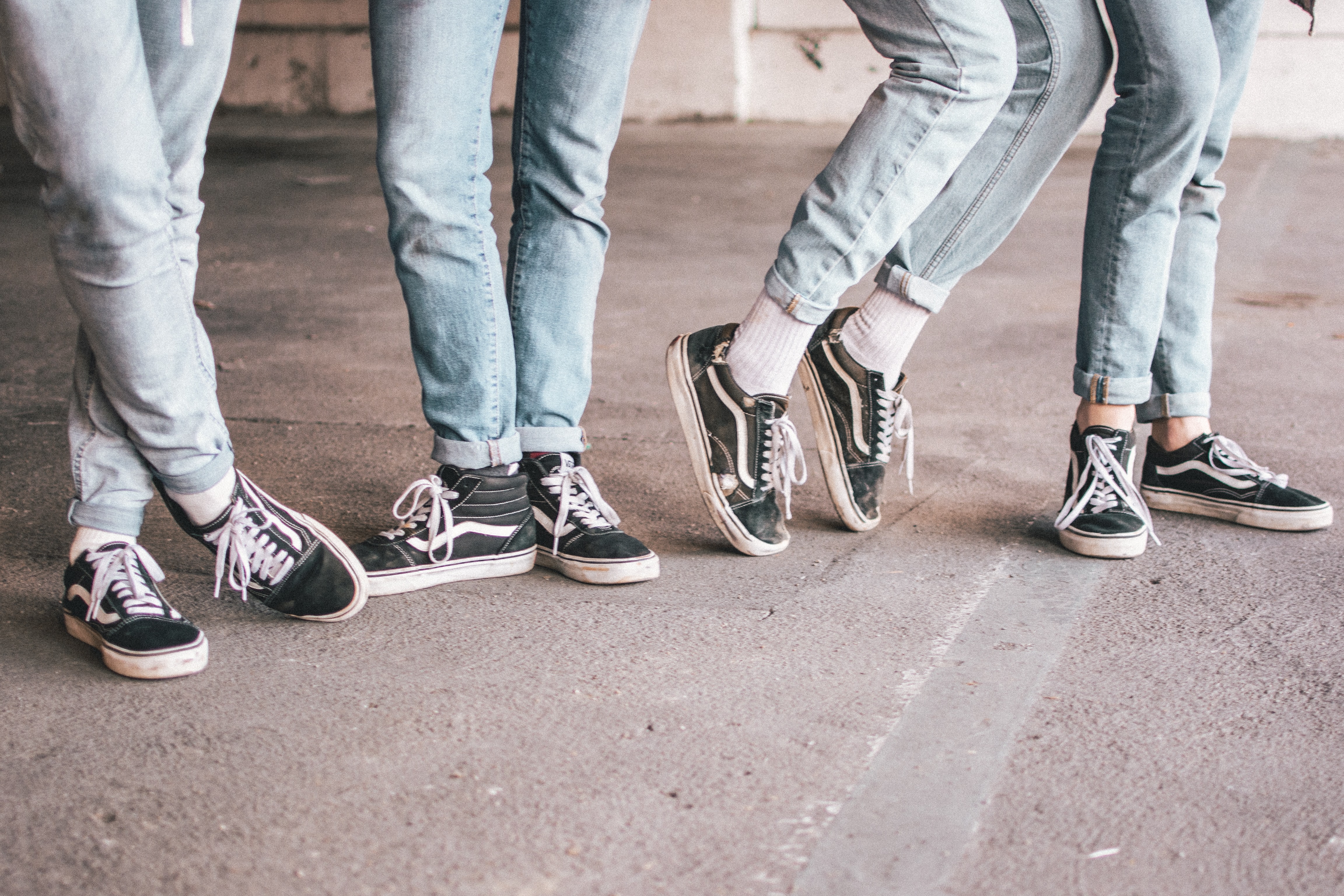 four pairs of legs in vans shoes and light jeans