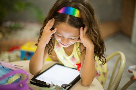 girl looking down at a tablet