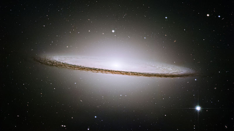 a disc-shaped white galaxy amid the stars