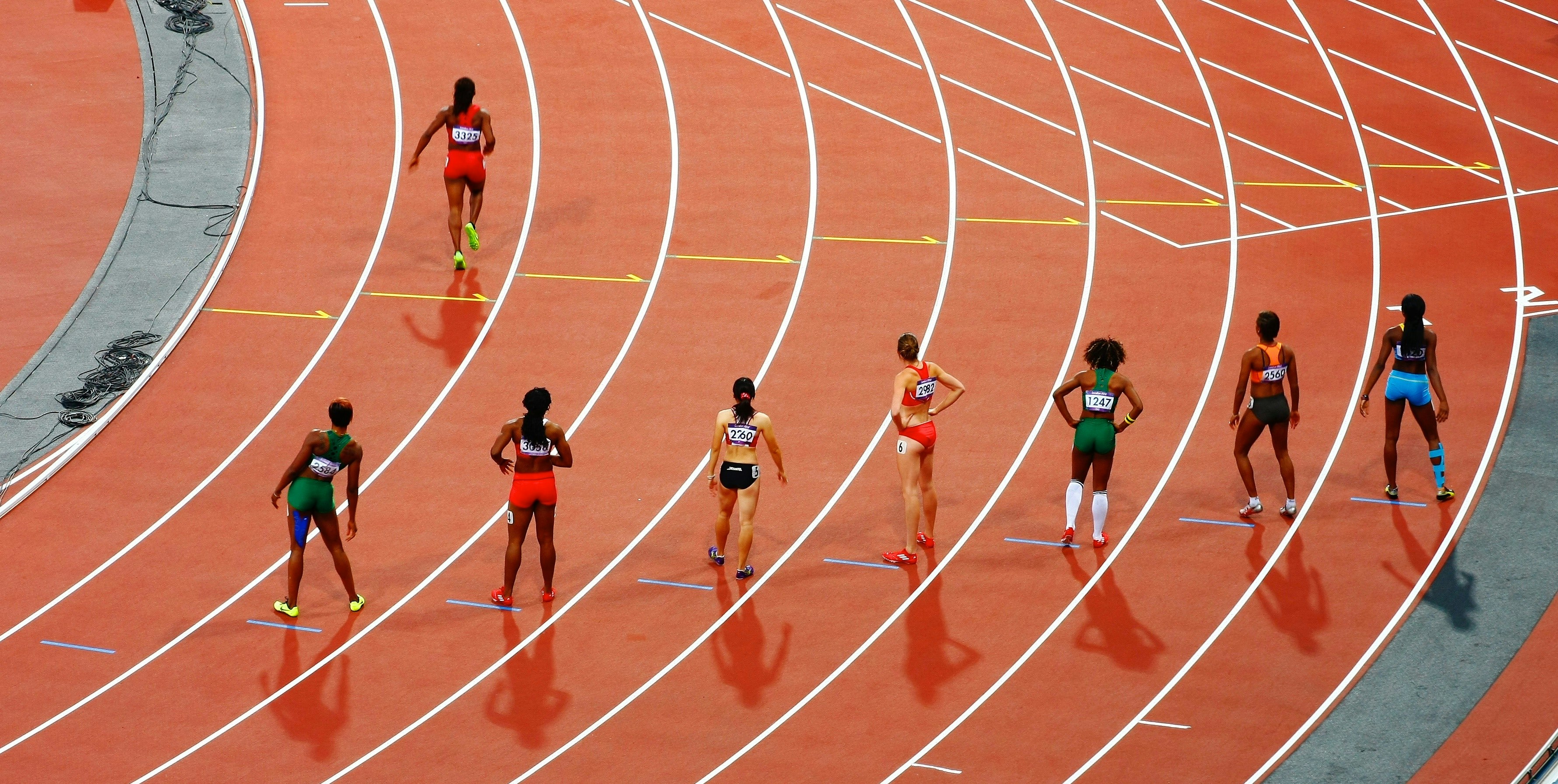 A photo of sprinters on a track waiting at the starting line.