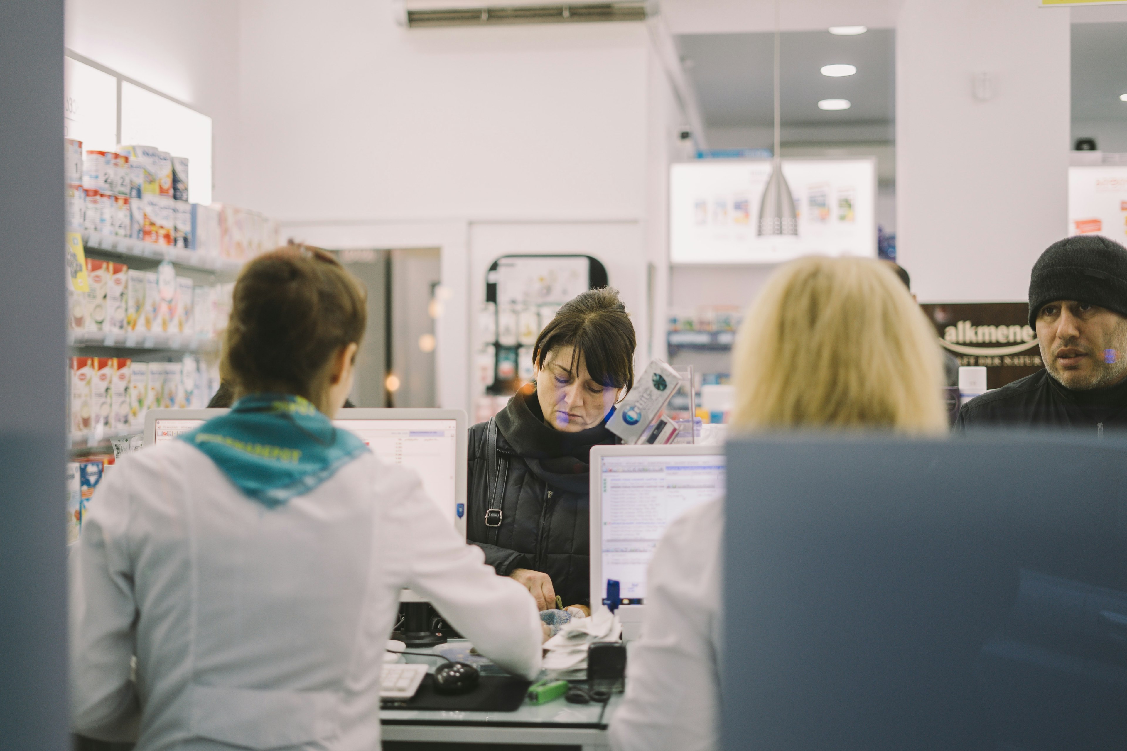 A woman completes a purchase at a pharmacy 