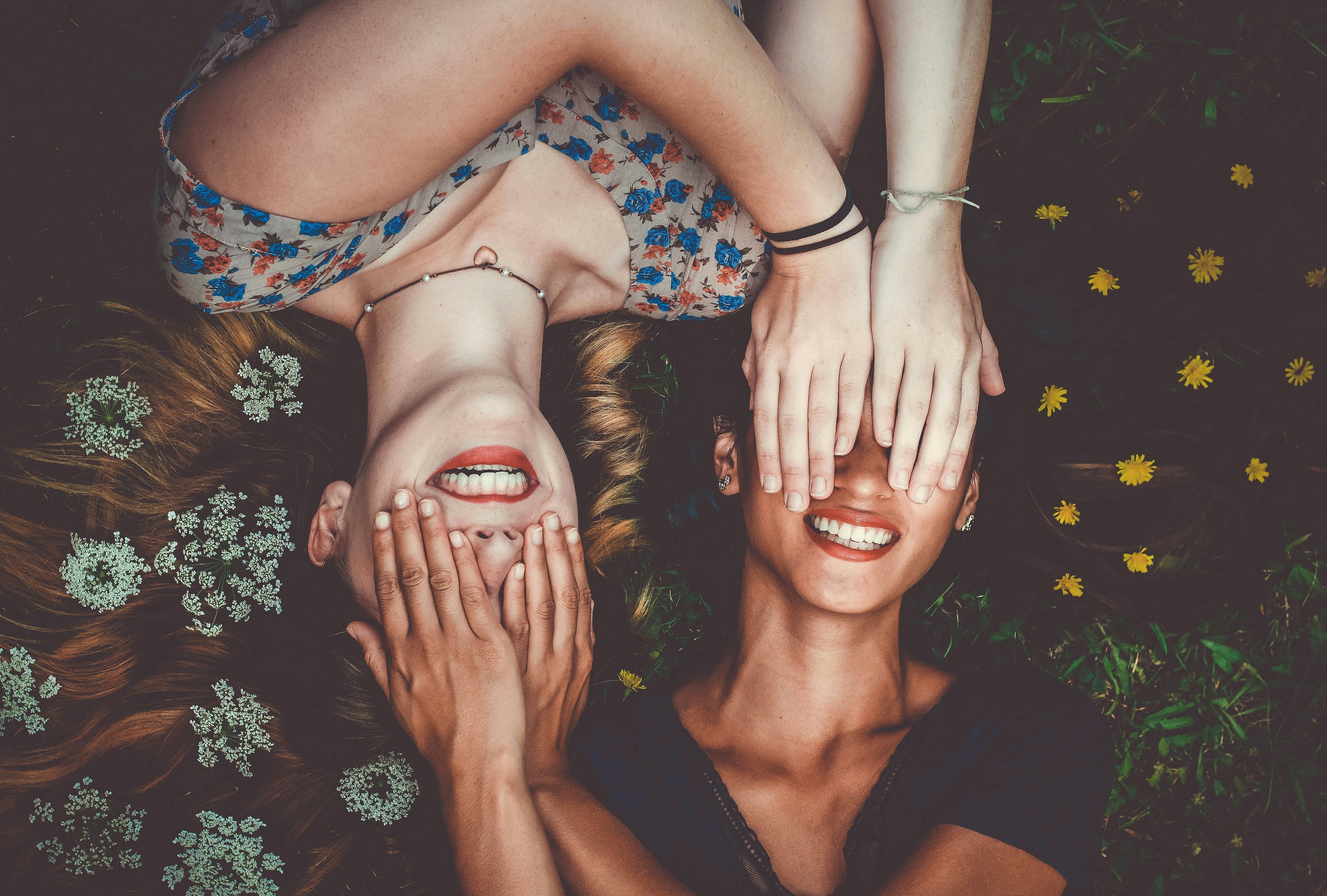two women smiling and covering each other's eyes