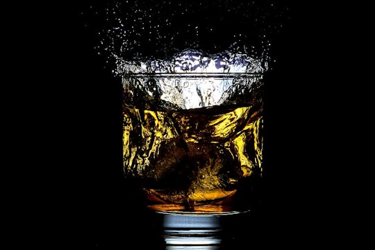 glass of liquid against a black background
