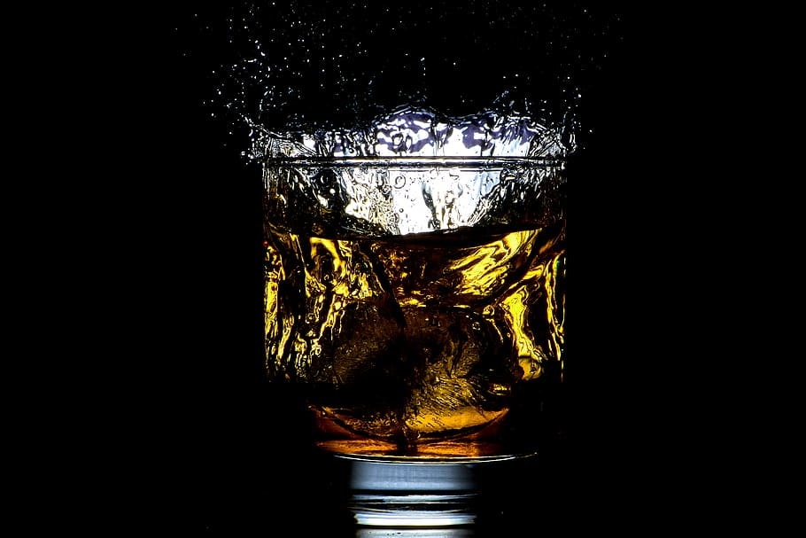 glass of liquid against a black background