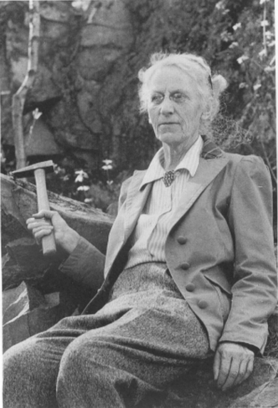 Alice Wilson posing, holding a small pickaxe. 