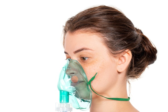 a woman wearing a green oxygen mask