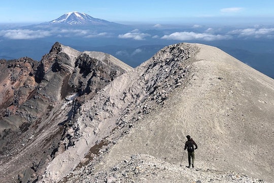 Hiking Mt. St. Helens person hiking along the crater of the mountain