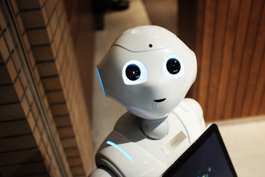 A white robot looks up towards the camera.