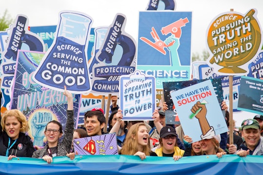 Protesters holding signs in support of science.