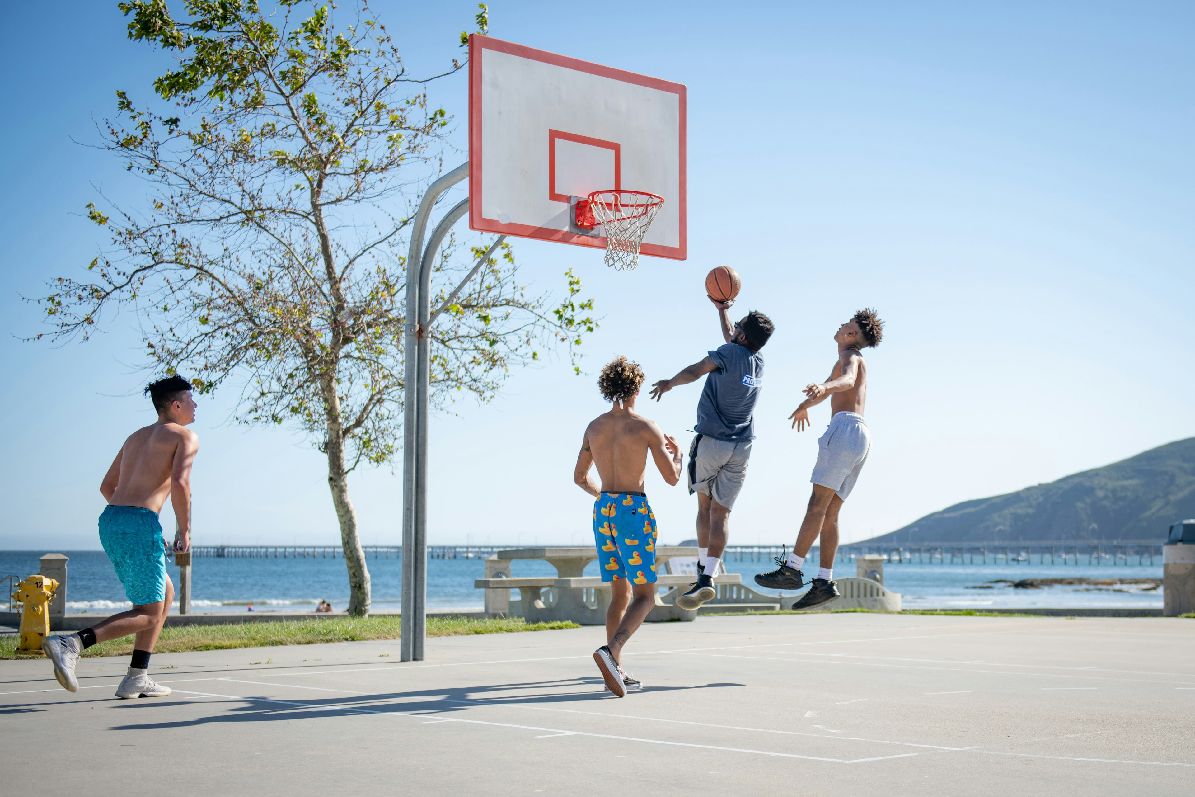 four people playing pick-up basketball
