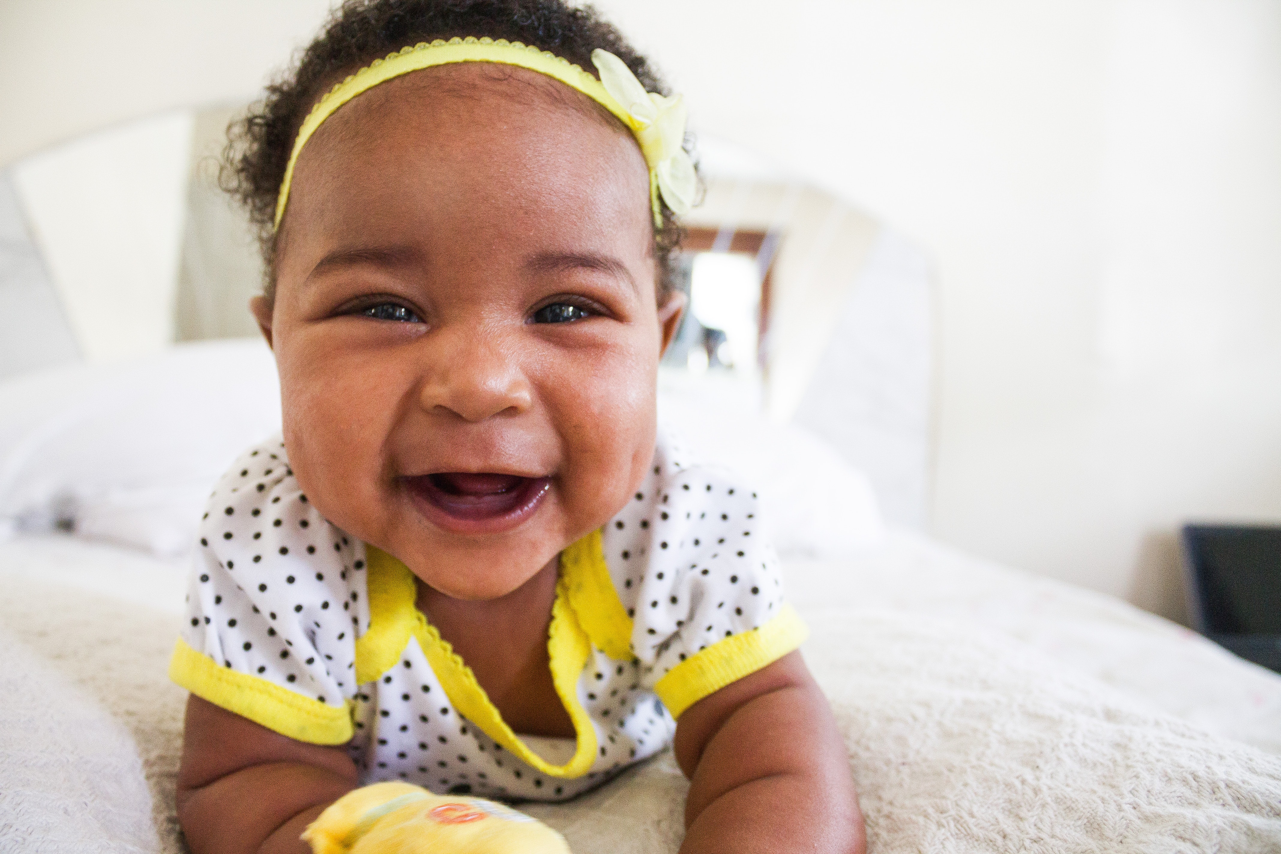 Baby smiling on a bed