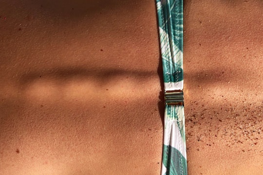 A photo of the skin around someone's spine, with some sand scattered here and there.