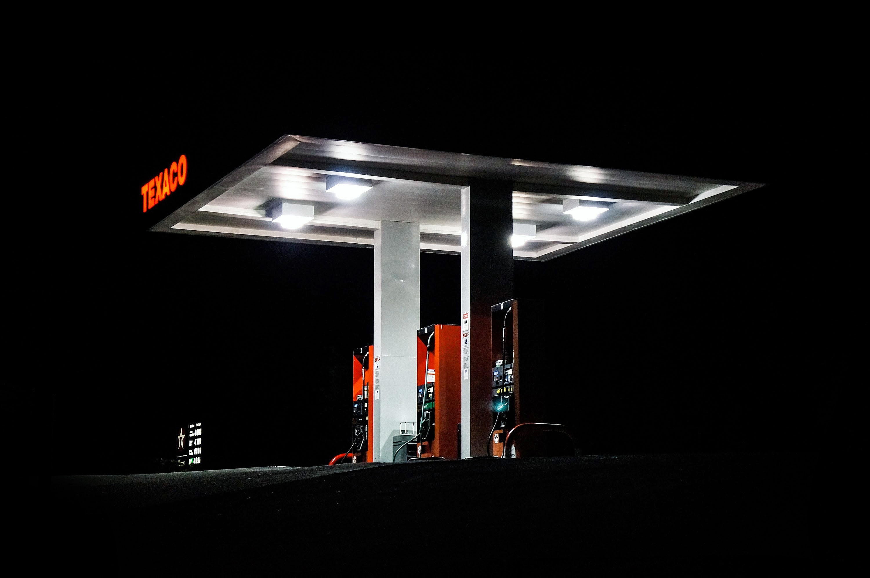 side angle photo of a texaco gas station taken at night