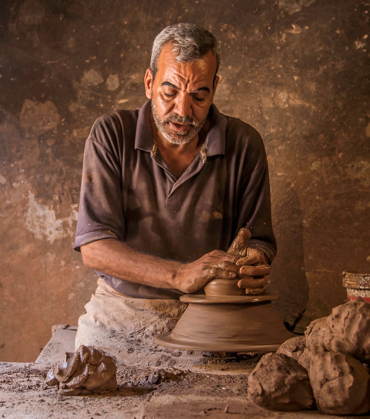 A man making a clay vase with his hands