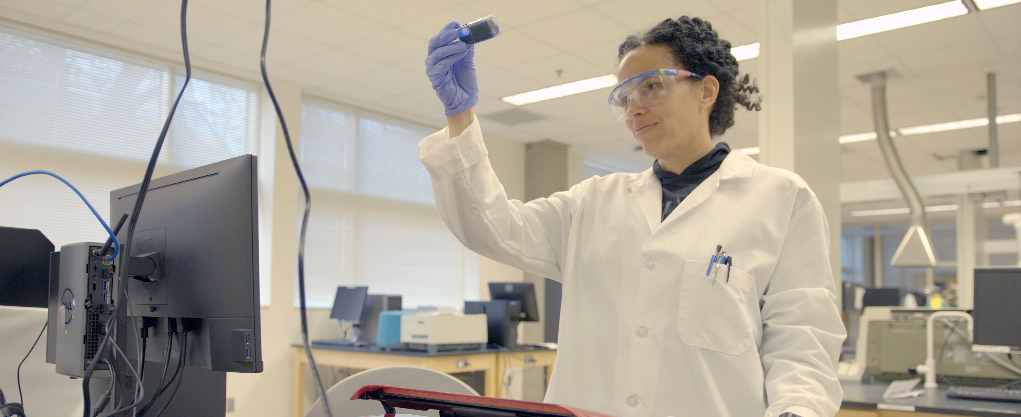 Chemist Raychelle Burks examines a sample while working in a lab