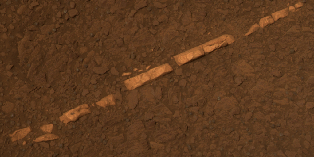 A thin, rectangular stone made of gypsum, surrounded by red Mars soil.