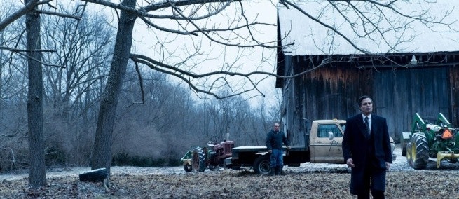 A still from the movie Dark Waters. A man walks in a field against an Appalachian backdrop.