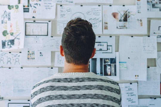 Person staring at wall with multiple pieces of data.