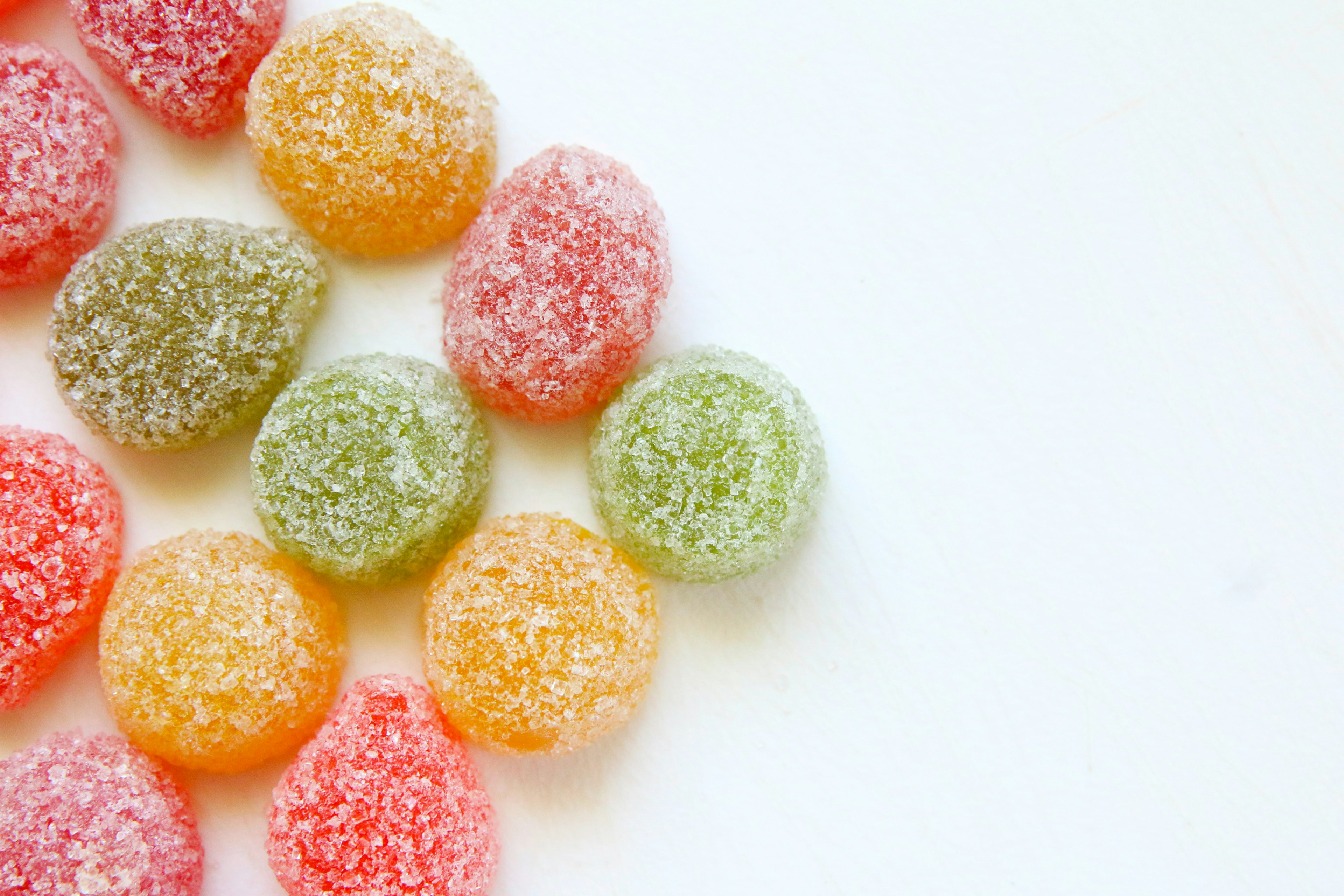 red, green, and yellow circular candies covered with sugar