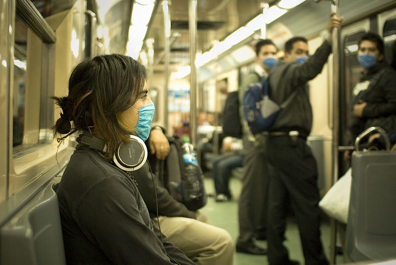 people on a train wearing flu masks