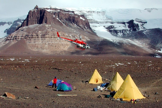 A helicopter prepares to land at Beacon Valley in the Dry Valleys of Antarctica. A helicopter prepares to land at Beacon Valley in the Dry Valleys of Antarctica.