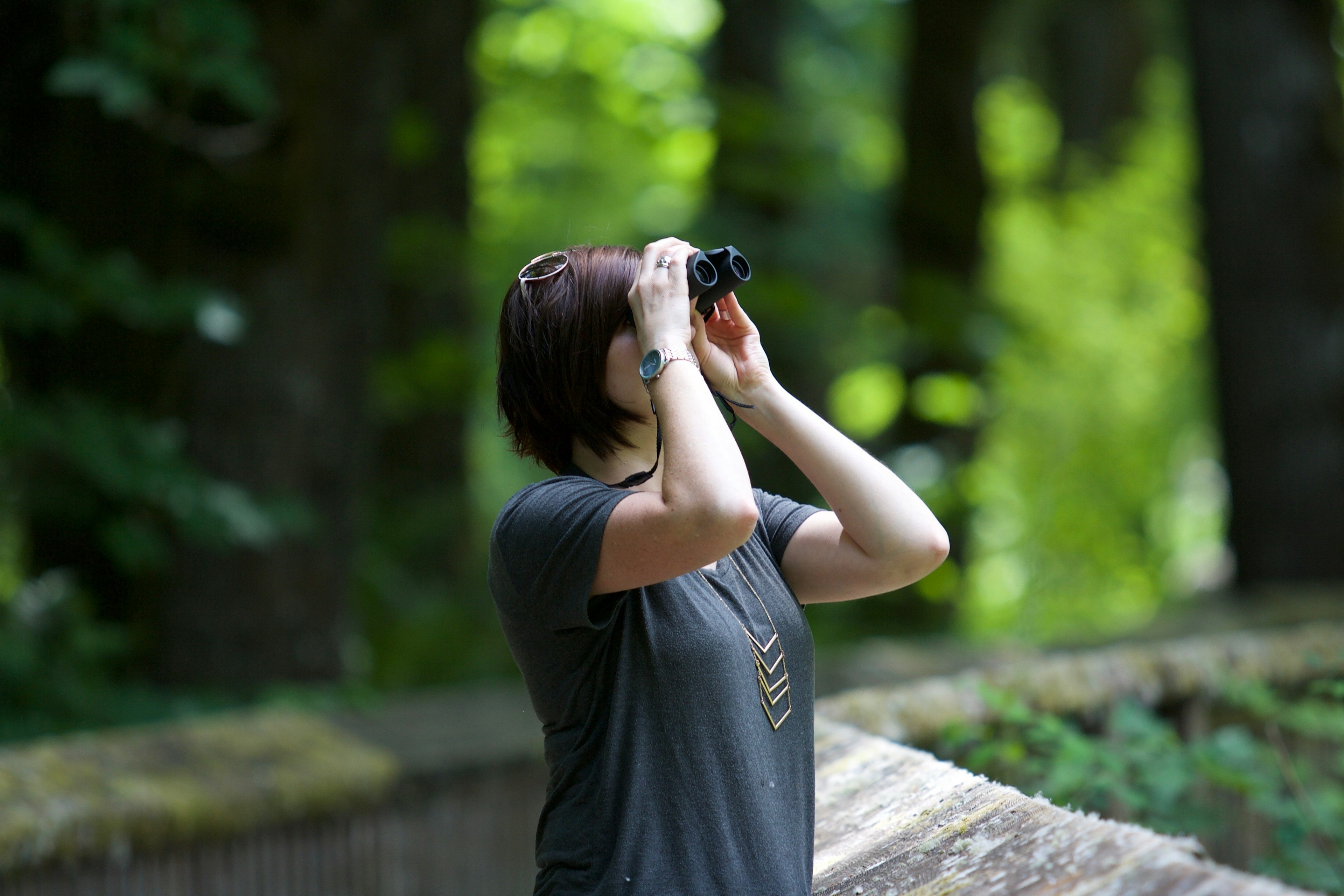 a woman standing outside looking through binoculars